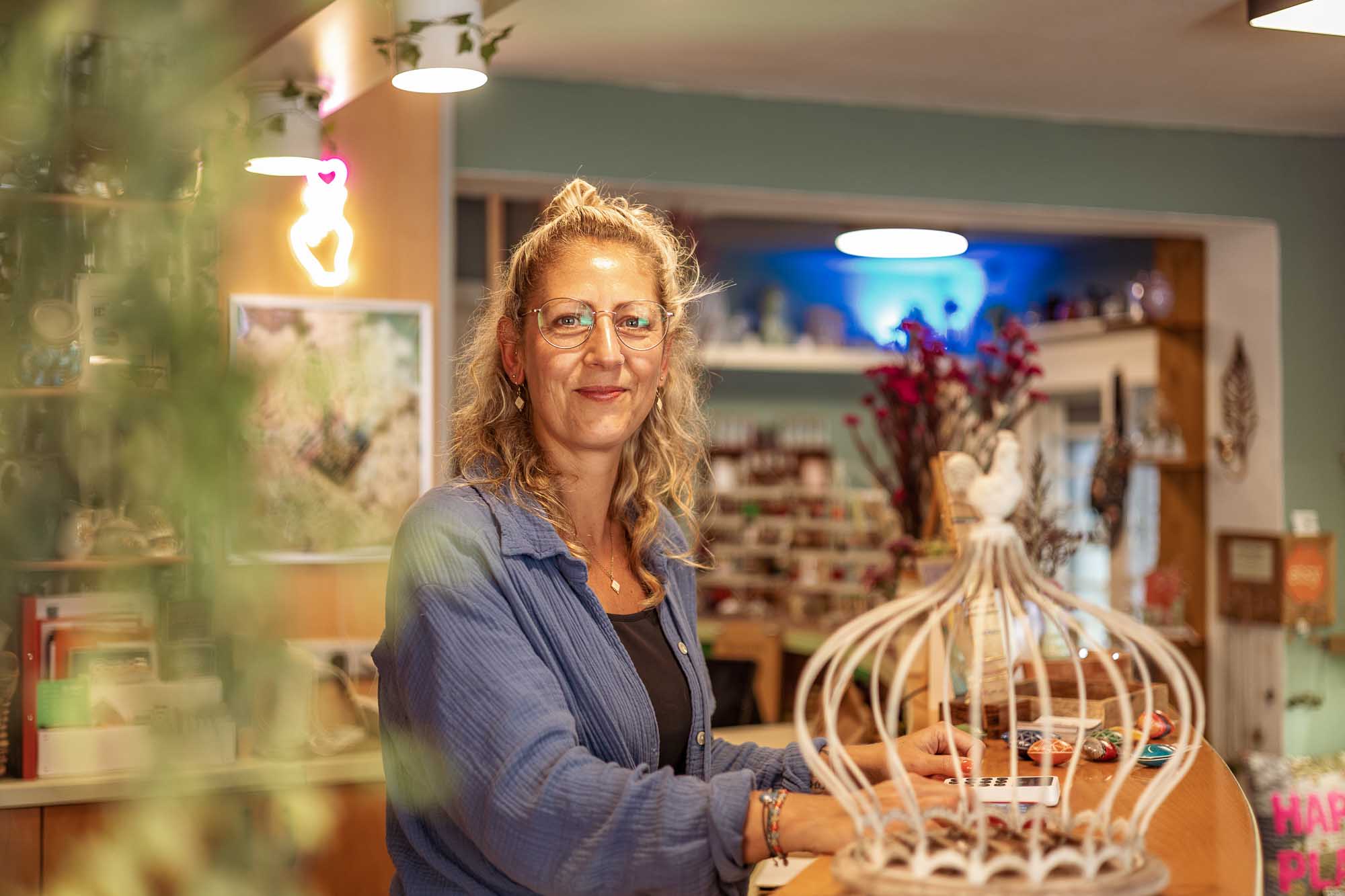 Authentische Businessfotos im Schmuckladen Liebling Strausberg Businessfotografie für kreative Unternehmerin: Ladenbesitzerin Liebling Strausberg am Verkaufstresen, handgefertigter Schmuck aus Blüten und Blättern, authentisches Portrait für Markenauftritt.
