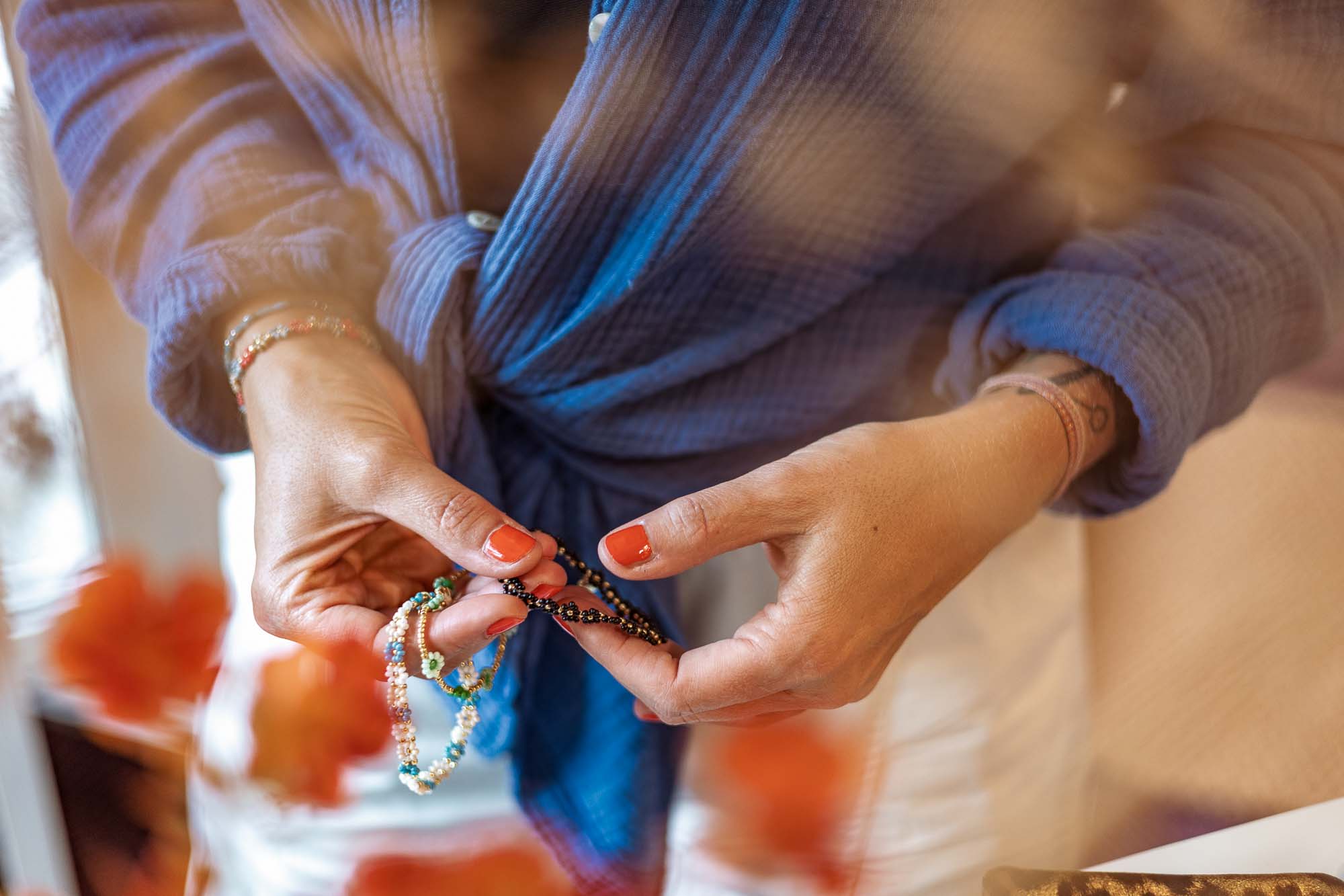 Detailaufnahme Schmuck Strausberg: Hände mit handgefertigten Armbändern aus echten Blüten und Blättern, kreative Produktfotografie für Liebling Strausberg.