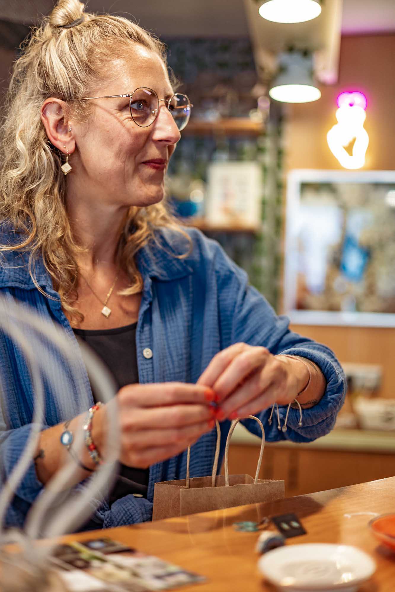 Businessfotografie Kreativbranche: Ladenbesitzerin Liebling Strausberg verpackt Schmuckstücke, nachhaltige Produkte aus Blüten und Blättern, authentische Markenfotografie.