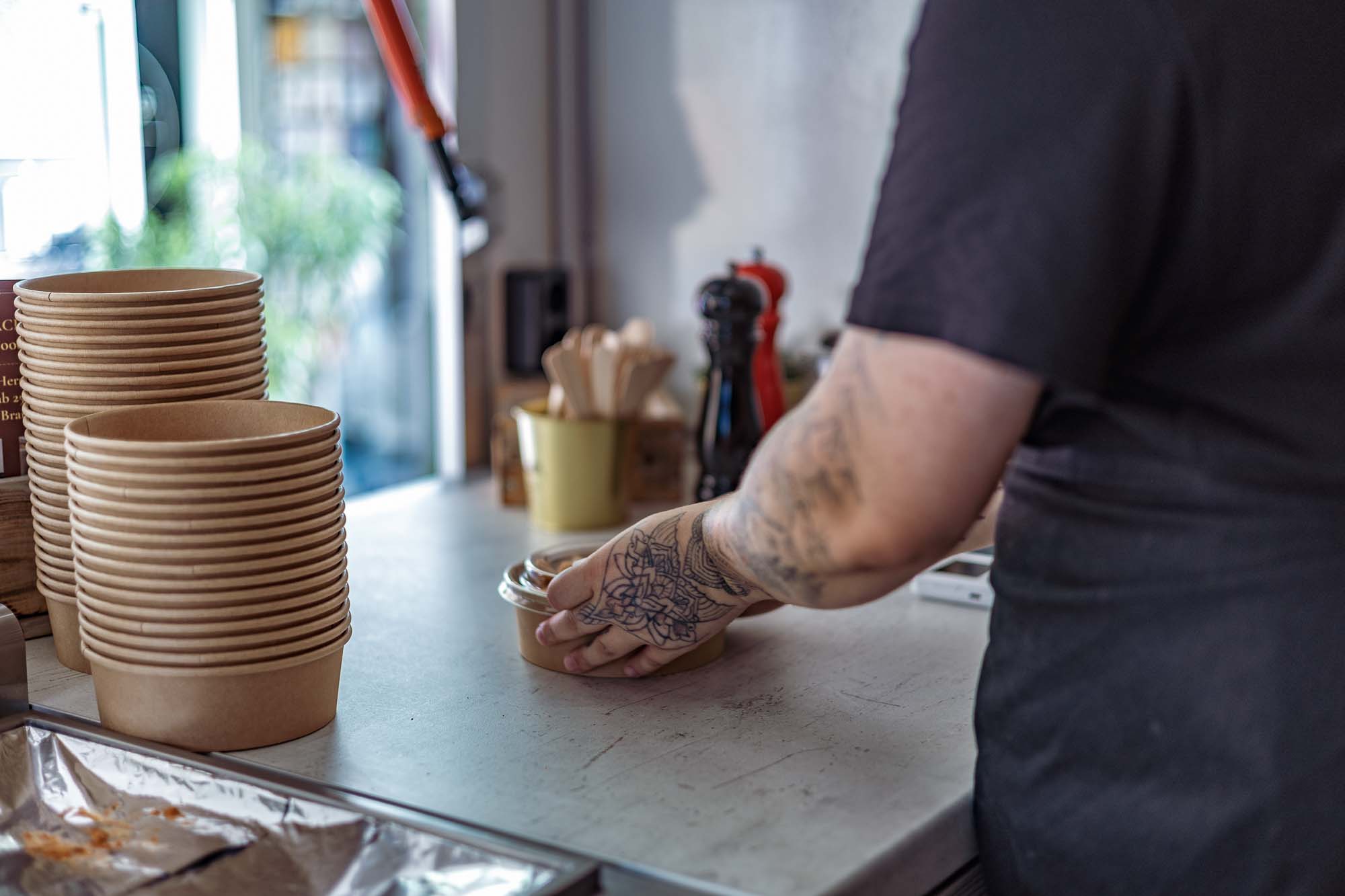 Authentische Businessfotografie Gastronomie: Anne von der Pasta Perle reicht frisch zubereitete Pasta in nachhaltiger Schale, Foodtruck Pasta Perle Berlin, Branding und Foodfotografie mit Fokus auf Handwerk und Qualität.
