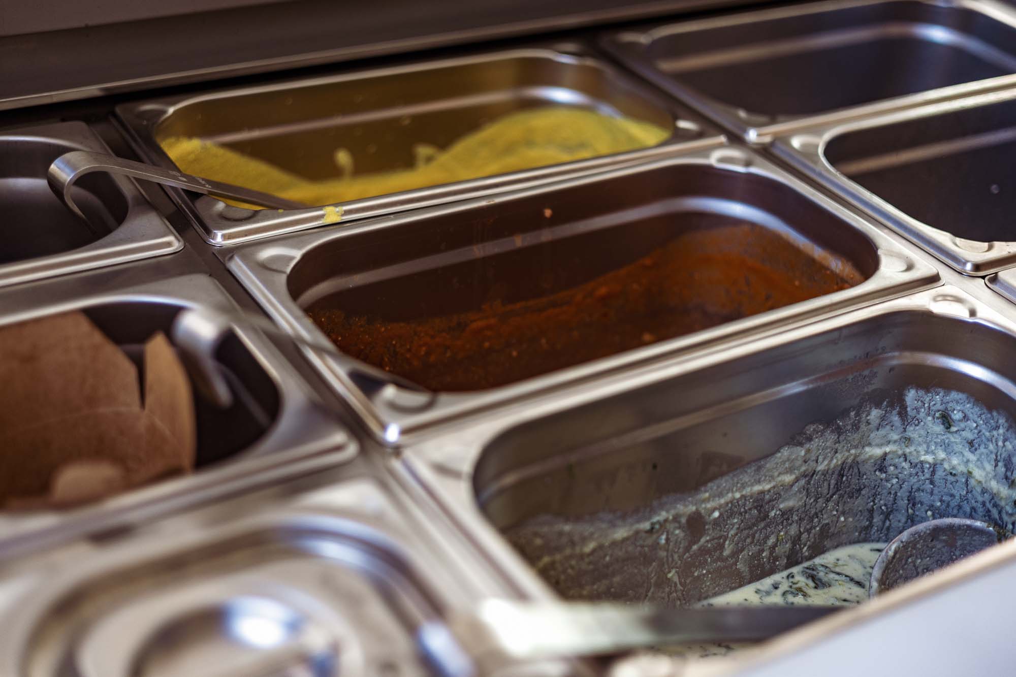 Detailaufnahme Pastasaucen in Edelstahl-Behältern, Foodfotografie und Gastronomie Branding Berlin, authentische Businessfotografie für Catering und Foodtruck.