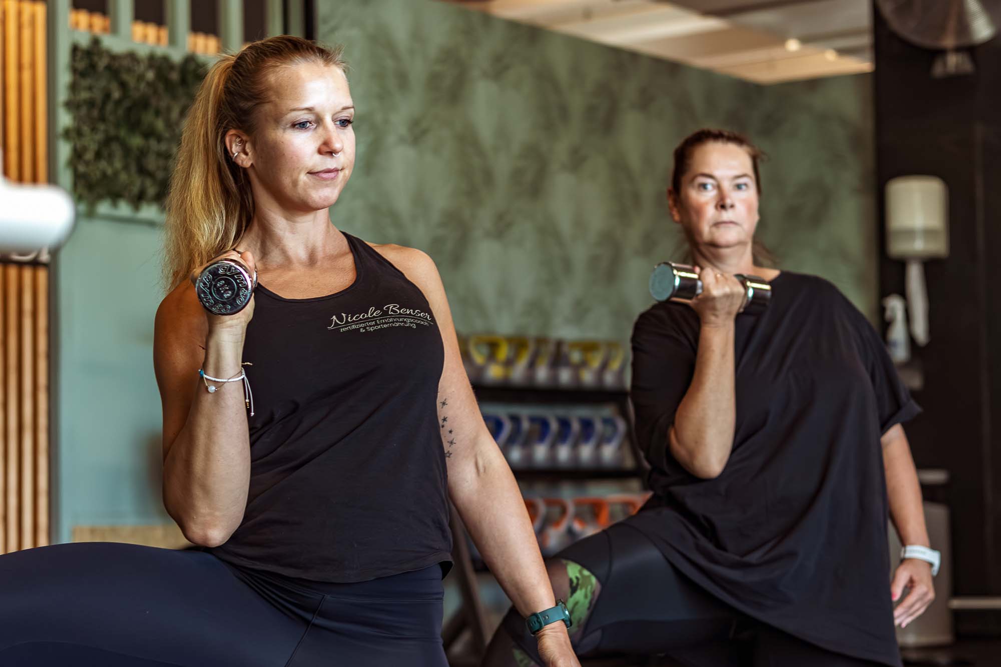 Personal Training mit Nicole Benser – authentische Businessfotografie Authentische Fitnessfotos im Training – Personaltrainerin Nicole Benser leitet Kurseinheit mit Hanteln in Mahlsdorf